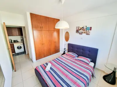a bedroom with a bed with a striped blanket at Seaside Heaven Apartment With Pool in Larnaka