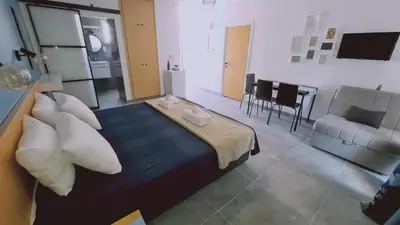 a room with a bed with pillows and a table at Nissi avenue 64 Studio 2 - Luxcyservices in Ayia Napa