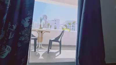 a table and chair in a room with a window at Nissi avenue 64 Studio 2 - Luxcyservices in Ayia Napa
