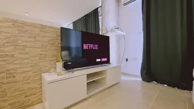 a living room with a television on a white entertainment center at STAY Lavish Studio in Ayia Napa
