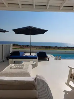 a patio with two couches and an umbrella at Narcissus 19 in Paralimni