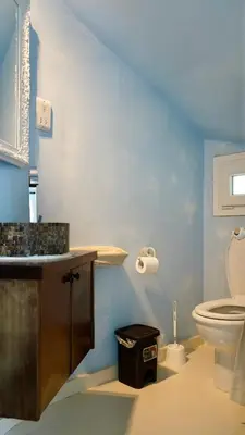 a blue bathroom with a toilet and a sink at Narcissus 19 in Paralimni