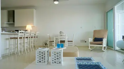 a kitchen and living room with chairs and a table at Narcissus 19 in Paralimni
