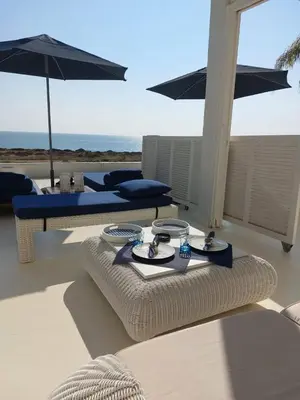 a table with two plates and an umbrella on a patio at Narcissus 19 in Paralimni