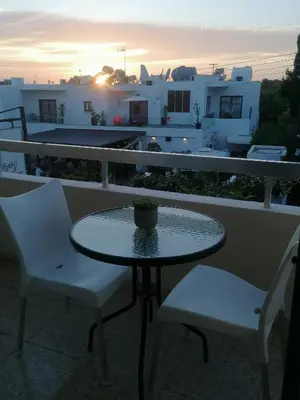 a table and chairs on a balcony with the sunset at PoliaNapa Nest in Ayia Napa
