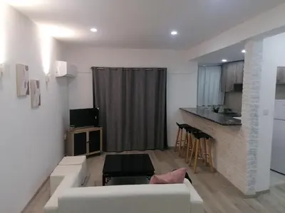 a living room with a white couch and a kitchen at PoliaNapa Nest in Ayia Napa