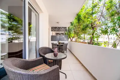 a balcony with wicker chairs and a table at SunnyVillas: 2BR Mythical Apt*Swimming Pool*AK04 in Paralimni