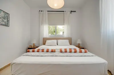 a white bedroom with a large bed with a window at SunnyVillas: 2BR Mythical Apt*Swimming Pool*AK04 in Paralimni