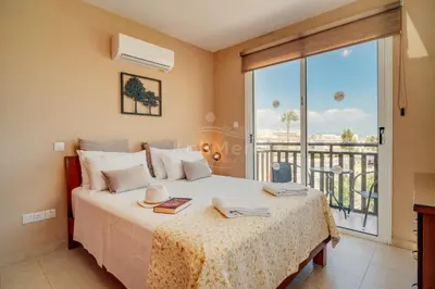 a bedroom with a bed and a balcony at Villa Sunrise Pernera in Paralimni