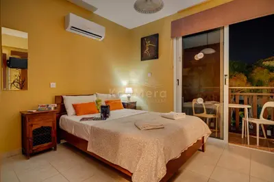 a bedroom with a bed and a balcony at Villa Sunrise Pernera in Paralimni