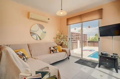 a living room with a couch and a tv at Villa Sunrise Pernera in Paralimni