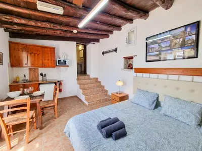 a bedroom with a bed and a table and a kitchen at Poseidon's Pool Paradise in Skarinou