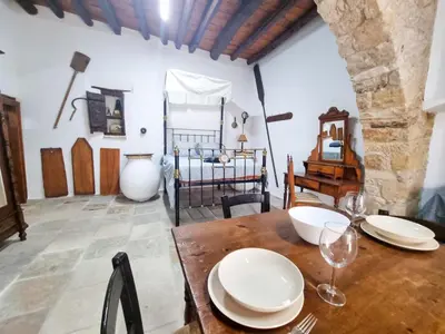 a dining room with a table and a bed at Poseidon's Pool Paradise in Skarinou