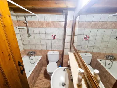 a bathroom with two toilets and a sink and a tub at Poseidon's Pool Paradise in Skarinou