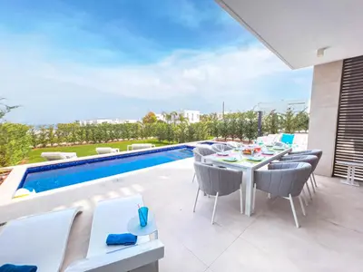 a patio with a table and chairs next to a swimming pool at Azure Seaview - Jade Villa in Protaras