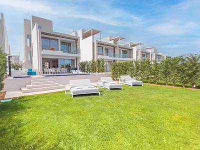 a villa with a lawn in front of a building at Azure Seaview - Jade Villa in Protaras