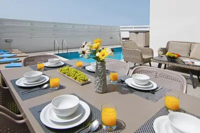 a dining room with a table with food and orange juice at Villa Dina in Protaras