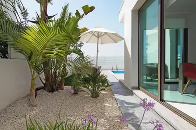 a house with a patio with an umbrella and plants at Villa Dina in Protaras