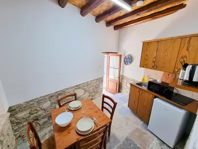 a kitchen and dining room with a wooden table at Aphrodite's Pool Retreat in Skarinou