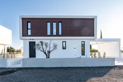 a white house with a brown roof at Tsiolakki Homes Luxury Villas in Protaras