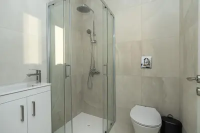a bathroom with a shower with a toilet and a sink at Tsiolakki Homes Luxury Villas in Protaras