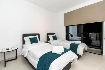 a bedroom with two beds and a large window at Tsiolakki Homes Luxury Villas in Protaras