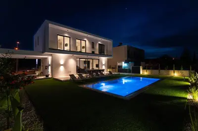 a house with a swimming pool at night at Tsiolakki Homes Luxury Villas in Protaras