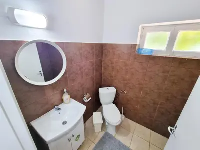 a bathroom with a toilet and a sink and a mirror at Aladdin's Hostel in Larnaka