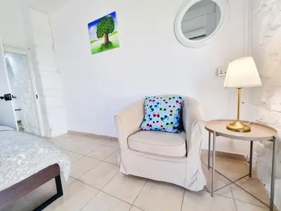 a bedroom with a chair and a table with a lamp at Aladdin's Hostel in Larnaka