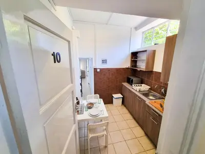 a small kitchen with a white door and a table at Aladdin's Hostel in Larnaka