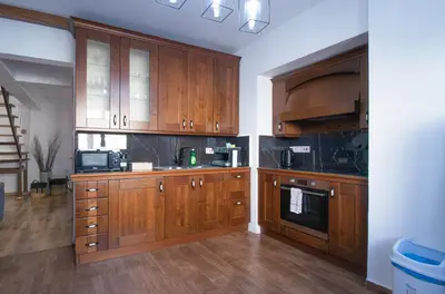 a large kitchen with wooden cabinets and appliances at Maestro Sea - View Apartment in Larnaka