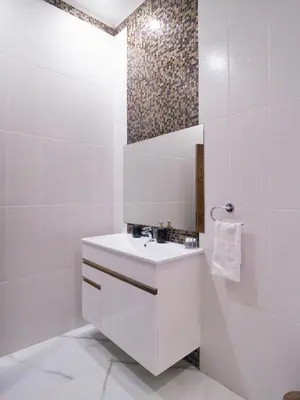 a white bathroom with a sink and a mirror at Maestro Sea - View Apartment in Larnaka