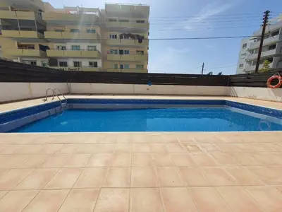 an empty swimming pool in front of a building at Andrea 3-Bedroom Apt in Mackenzie in Larnaka