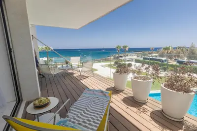 a balcony with a deck with a view of the ocean at Thalassa Luxury Apartment in Protaras